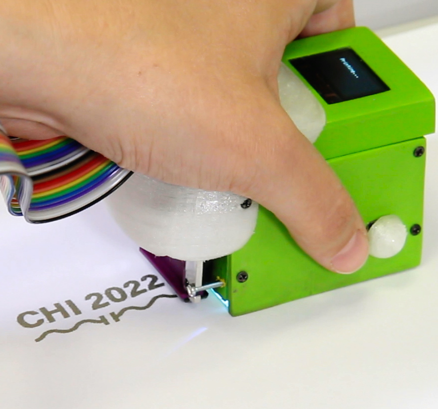 Print-A-Sketch: A Handheld Printer for Physical Sketching of Circuits and Sensors on Everyday Surfaces